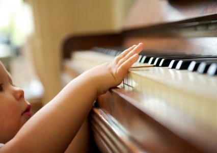 małe dziecko próbuje grać na pianinie