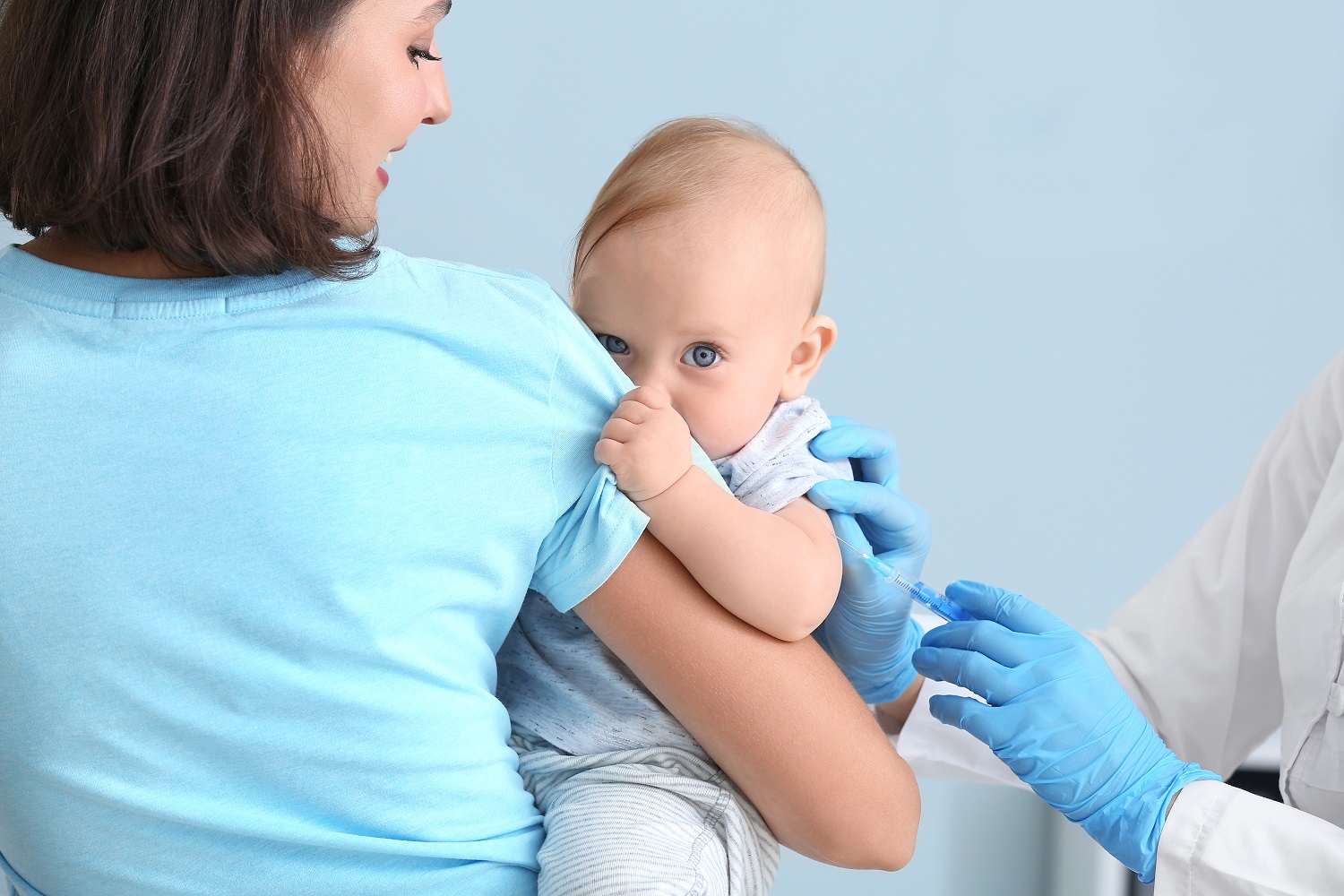 niemowlę na rękach matki otrzymujące szczepienie